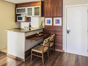a kitchen with a counter and a table and chairs at Mercure Sao Caetano do Sul in São Caetano do Sul +109 photos