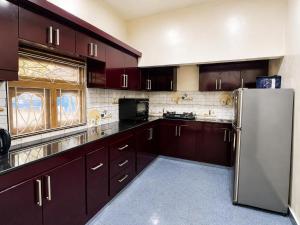 a kitchen with brown cabinets and a stainless steel refrigerator at DNN Brothers Villa in Jaffna