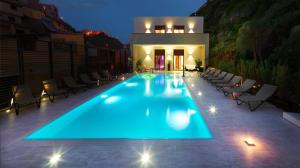 a swimming pool with blue lights on a patio at Hotel & SPA Riviera Castelsardo in Castelsardo