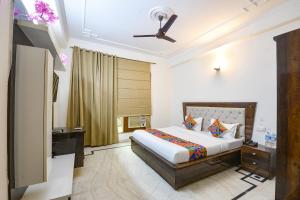 a bedroom with a bed and a ceiling fan at FabHotel The Arjun Sushant lok - Iffco Chowk Sector 29 in Gurgaon
