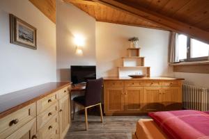 a bedroom with a desk with a computer and a bed at Apartments Rezia in Ortisei