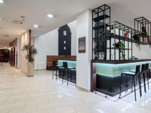 a lobby with a bar with stools at Hotel Mercure Graz City in Graz
