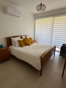 a bedroom with a large bed with yellow pillows at WHTheGardens in Pyla