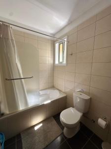 a bathroom with a toilet and a shower and a tub at WHTheGardens in Pyla