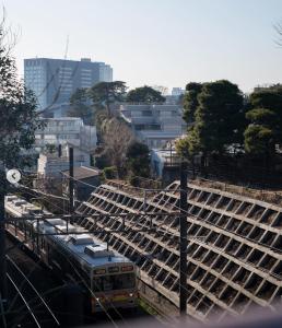 a train is on the tracks in a city at The Aoca Tokyo Kaminoge in Tokyo