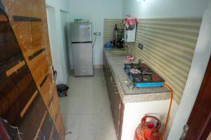 a kitchen with a stove and a refrigerator at Saanjh Private Pool Villa Jaipur in Jaipur