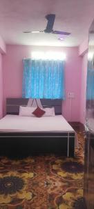 a bedroom with a large bed with a blue curtain at Hotel Sunrise inn in Nārdiganj