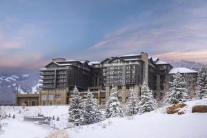 a large building in the snow with snow covered trees at Grand Hyatt Deer Valley in Park City