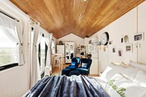 ein Zimmer mit einem Bett und einem Stuhl und einer Uhr in der Unterkunft Anadlu in Beechworth