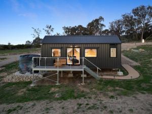 ein kleines schwarzes Häuschen mit Veranda in der Unterkunft Anadlu in Beechworth