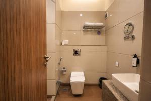 a bathroom with a toilet and a sink at Hotel Dwarkamai, A Pure Vegetarian Hotel in Nagpur