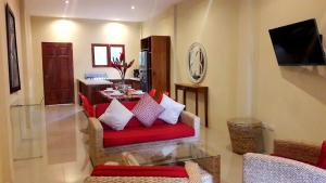 a living room with a red chair and a table at Hotel Plaza Marbella Granada in Granada