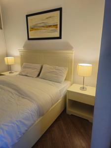 a bedroom with a bed with two lamps on tables at The Terraces by 12th Avenue in Murree +4 photos