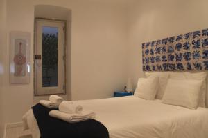 リスボンにあるBairro Alto 27のベッドルーム1室(白いベッド1台、タオル付)