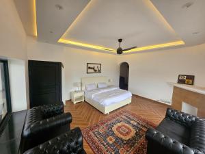 a bedroom with a bed and black leather furniture at The Terraces by 12th Avenue in Murree