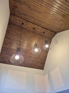 a group of three lights hanging from a ceiling at Hill House Marisel in Mărişel
