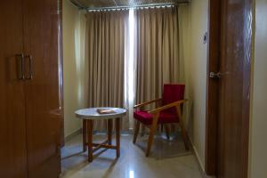a room with a table and a chair and a window at Briddhishree Palace in Guwahati