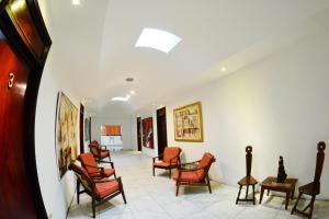 a waiting room with chairs and paintings on the walls at Hotel Europeo in Managua