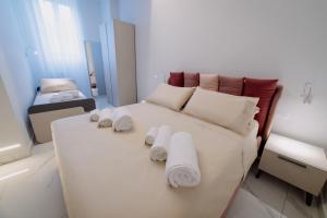 a bedroom with a white bed with towels on it at Domoo Boutique Hotel in Torraca