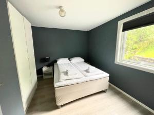 a bedroom with a bed and a window at Fjord Apartments in Dimmelsvik
