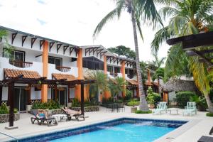 a resort with a swimming pool and palm trees at Hotel Europeo in Managua