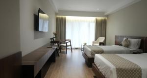 a hotel room with two beds and a desk at Surya Grand Hotel in Kalpetta +75 photos