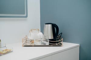 a kitchen counter with a basket of dishes and a coffee maker at The Gardens in Marracuene