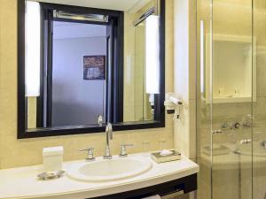 a bathroom with a sink and a glass shower at Novotel Florianopolis in Florianópolis +126 photos