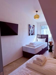 a bedroom with two beds and a tv on the wall at Parkside Apartments Rust in Rust