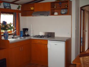 a kitchen with a sink and a stove top oven at Le réveil des oiseaux in Saint-Michel