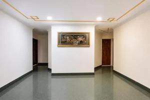a room with white walls and a painting on a wall at FabHotel Le Sancy in New Delhi