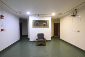 a chair in an empty room with a painting on the wall at FabHotel Le Sancy in New Delhi