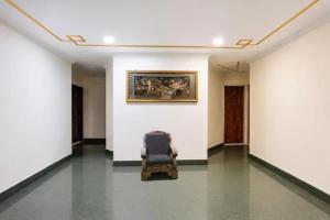 a chair in a room with a painting on the wall at FabHotel Le Sancy in New Delhi