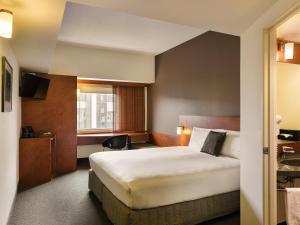 a hotel room with a bed and a window at Ibis Christchurch in Christchurch