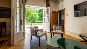 a living room with two chairs and a glass table at Château de Saulon in Saulon-la-Rue