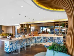 a restaurant with a bar with blue and white chairs at Novotel Istanbul Zeytinburnu in Istanbul