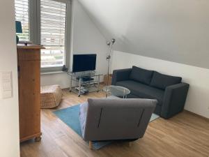 a living room with a couch and a chair at Ruhige 2-Zimmer Ferienwohnung FeWo Bodensee in Öhningen
