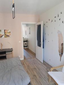 a bedroom with a bed and birds on the wall at T2 Cosy, agréable fonctionnel et douillet, 1 lit 140 et un BZ , Wifi gratuit, boîte à clés, proche commerces et gare routière, linge de lit et toilette offerts à partir de 4 nuits in Graulhet