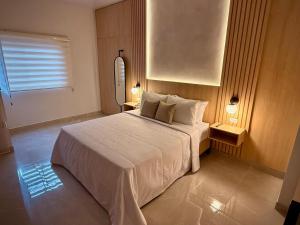 a bedroom with a large white bed and a window at Cumaé Hotel Boutique in Quimbaya