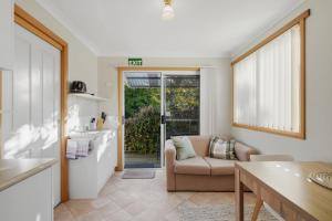 a kitchen and living room with a couch and a table at Sunlit Garden Granny Flat in Devonport
