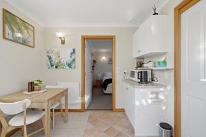 a kitchen and dining room with a table and a microwave at Sunlit Garden Granny Flat in Devonport