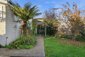 a house with a palm tree in the yard at Sunlit Garden Granny Flat in Devonport