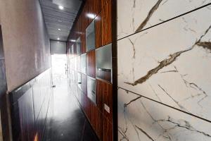 a hallway with marble floors and a wall with a door at Hotel Rashika Palace Near Sindhi Camp Bus Stand, Jaipur in Jaipur