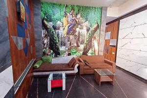 a living room with a painting on the wall at Hotel Rashika Palace Near Sindhi Camp Bus Stand, Jaipur in Jaipur