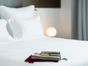 a stack of books sitting on top of a bed at Zamzam Pullman Makkah in Mecca