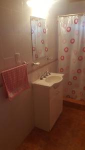 baño con lavabo y cortina de ducha en Cabañas Paihuen en Trevelín
