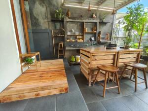 a kitchen with a wooden table and two stools at Homestay Omah in Tabanan