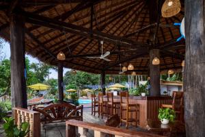 a patio with a bar and chairs and a pool at Sandy Beach Bungalows by EHM in Koh Rong Sanloem