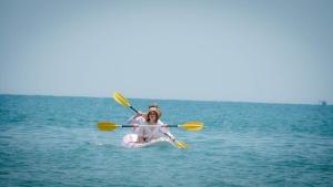 two people are sitting on a raft in the water at Sandy Beach Bungalows by EHM in Koh Rong Sanloem
