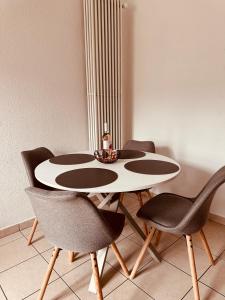 a dining room table with chairs and a bottle of wine at Heure Cosy in La Chaux-de-Fonds